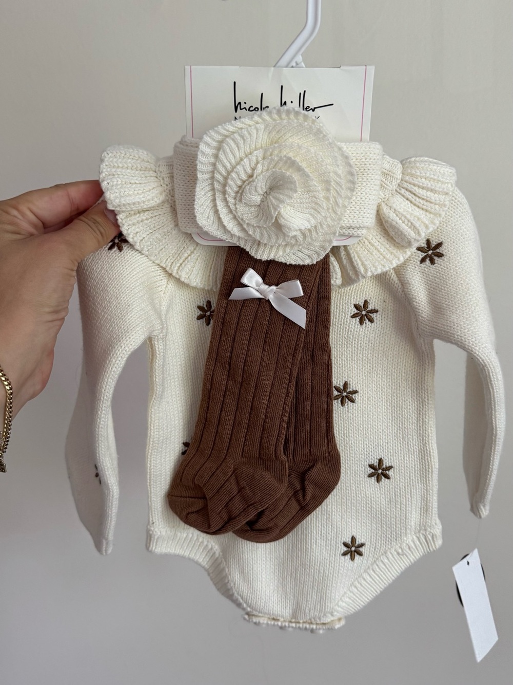 Nicoli Hiller Cream Knit Baby Onesie with Brown Tights & Rose Headband